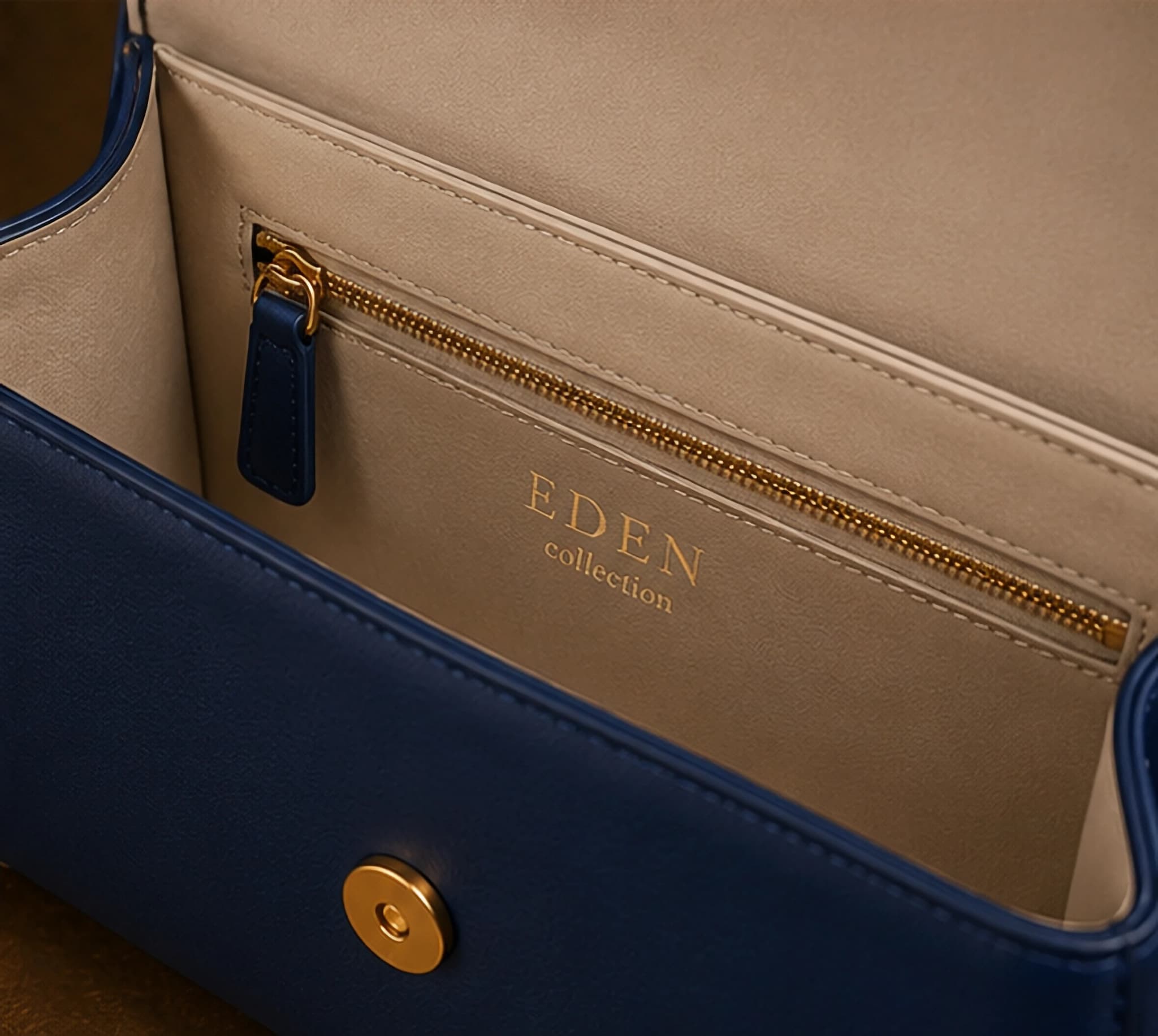 Interno del bauletto blu navy con fodera tortora e la scritta EDEN collection impressa in oro